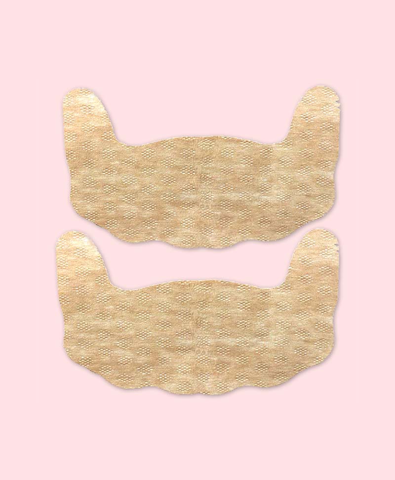 Two beige adhesive bras show on a pink background