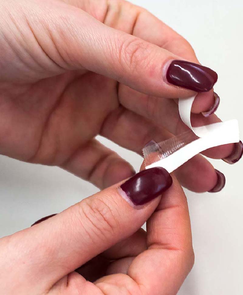 Image of women halide Flash tape in hands. She is pealing back the single side of tape